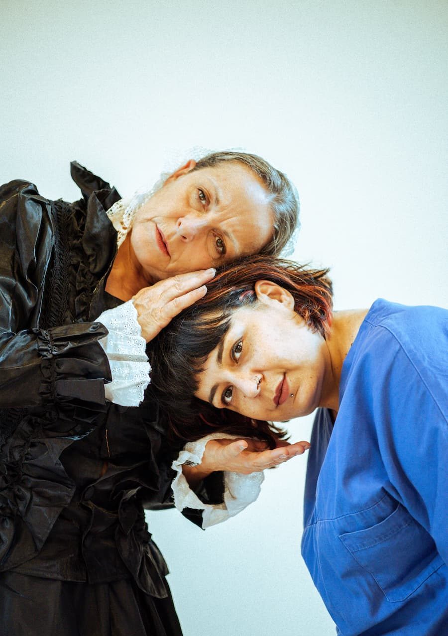 Shooting per lo spettacolo Arte Bella con le due protagoniste Florence Nightingale e Teresa. Florence, a destra, porge una mano verso Teresa, a sinistra, che ci poggia la testa sopra. Florence copre la testa di Teresa con l'atra mano e appoggia la sua testa a sua volta su quella di Teresa.