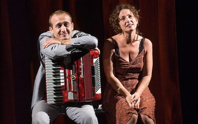 Giorgio e Helena sono seduti su una panchina. Giorgio ha una fisarmonica appoggiata sulle gambe, a cui lui stesso si appoggia a braccia conserte. Guardano l'orizzonte con sguardi trasognati.