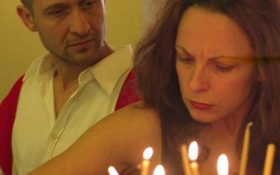 In primo piano, Helena, corrucciata, mette delle candele accese in una torta. Dietro di lei, Giorgio la guarda.